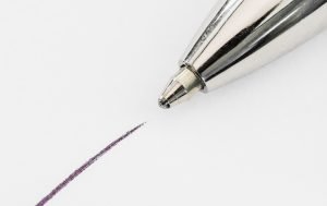 Close up of top of ball point pen and line drawn on white paper, writing, letter, school